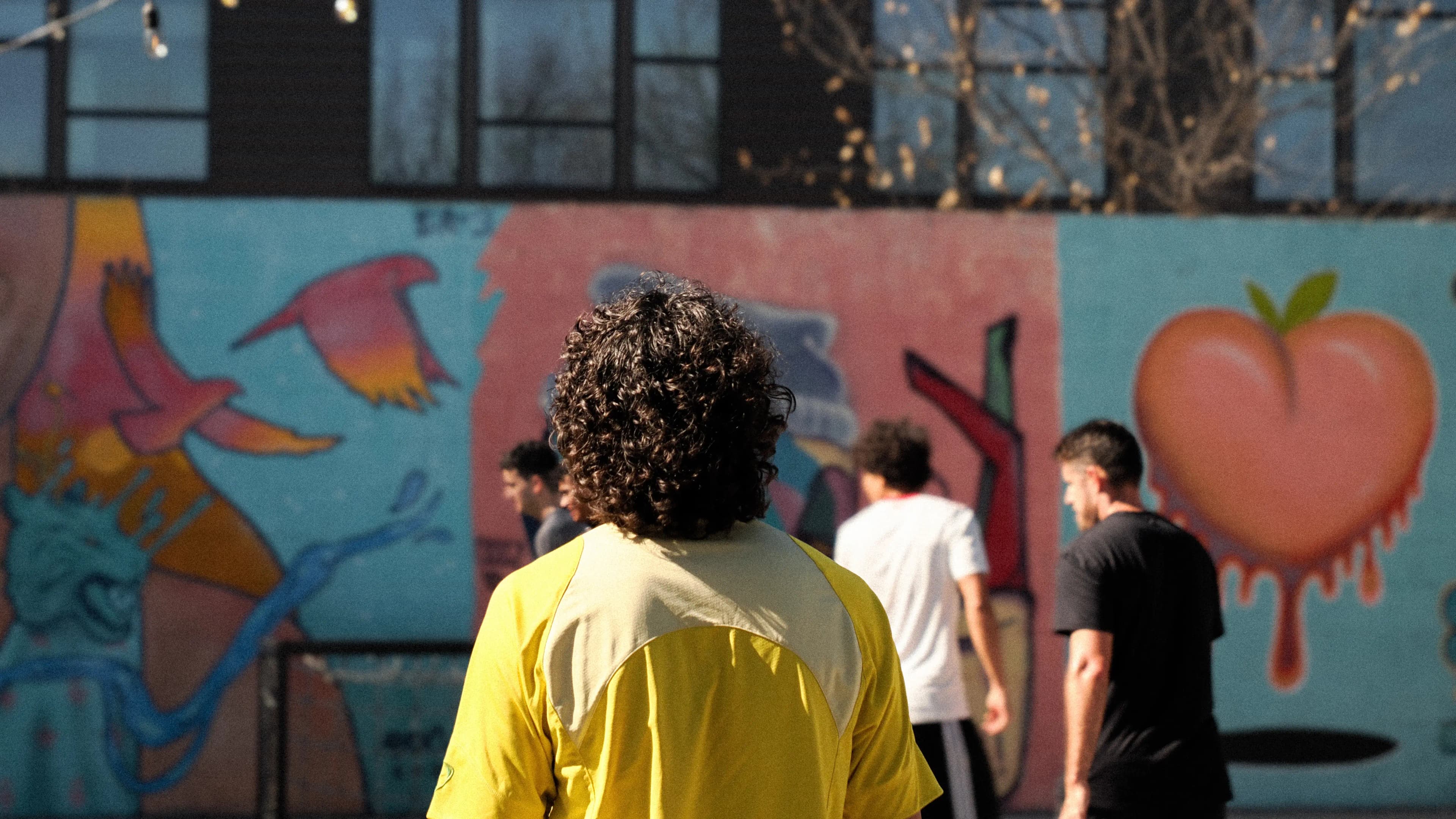 Artist at work on a soccer-themed mural